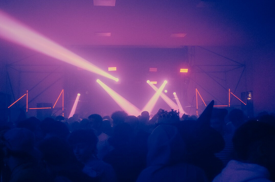 Stage lighting rig with bright beams over a live show set